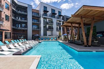 A swimming pool in front of a modern apartment building at Sterling Nashville West Apartments, Nashville, TN, 37209